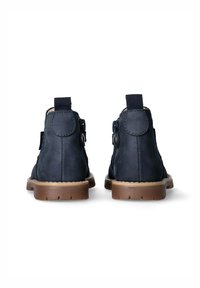 Stivaletti alla caviglia in pelle blu navy con punta tonda, colletto imbottito e zip laterale. Suola in gomma marrone chiaro con battistrada texture.