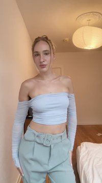 Lyseblå off-shoulder topp med lange ermer, kombinert med høyt liv mintgrønne bukser som har belte og plisserte detaljer.