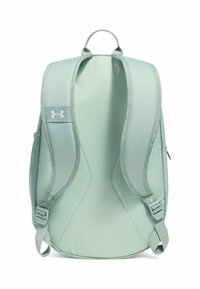 Zaino verde chiaro con spallacci imbottiti, maniglia superiore e patch con logo. Tessuto liscio con un design elegante e affusolato.