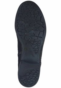 Suela de zapato negra con goma texturizada, que presenta un patrón agrietado, diseño flexible y el nombre de la marca "Josef Seibel" grabado.