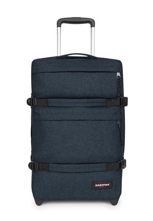 Maleta de tela suave azul oscuro con dos correas de compresión horizontales, un asa telescópica, un bolsillo delantero con cremallera y el logo de Eastpak cerca de la base.