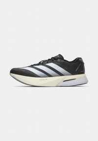 Chaussure de course Adidas en noir et blanc avec semelle Lightstrike Pro et trois bandes blanches sur le côté sur fond uni.