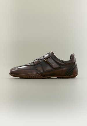 Chaussure décontractée en cuir marron avec bout rond, fermeture latérale par bride et semelle en caoutchouc texturée, vue de profil sur un fond neutre.