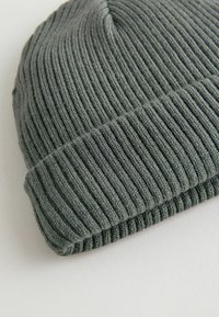 Graue Strickmütze mit geripptem Muster, runder Oberseite und umgeschlagenem Saum. Hergestellt aus weichem Stoff, ideal für legere Kleidung bei kaltem Wetter.