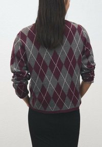 Pulover în model argyle bordeaux și gri, realizat dintr-un material tricotat moale. Are decolteu rotund și mâneci cu manșete, cu un croi scurtat.