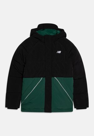 Veste matelassée à capuche avec le haut et les manches noirs, le bas vert foncé, des bandes diagonales blanches et un petit logo blanc sur la poitrine.