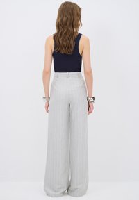 Lichtgrijze, gestreepte wijde broek met een hoge taille, gemaakt van een gladde stof, met zijzakken en een nette afwerking.