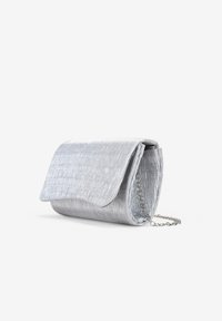 Bolso de mano metálico plateado con un acabado texturizado, cuenta con una solapa de pliegue y una cadena plateada. Forma rectangular compacta.