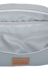 Lichtgrijze stoffen tas interieur met een gladde textuur, ritssluiting en een leren patch met het "Johnny Urban" logo.