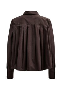 Chemise marron foncé à manches longues avec un large dos présentant plusieurs plis verticaux et un col classique.