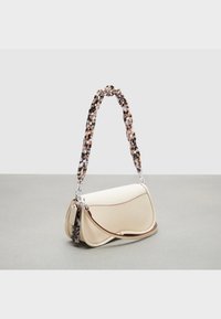 Beżowa torebka o fakturowanej powierzchni i zaokrąglonym kształcie, z wzorzystym paskiem w odcieniach brązu i kremu. Ozdobiona srebrnymi dodatkami i brązowym szwem.