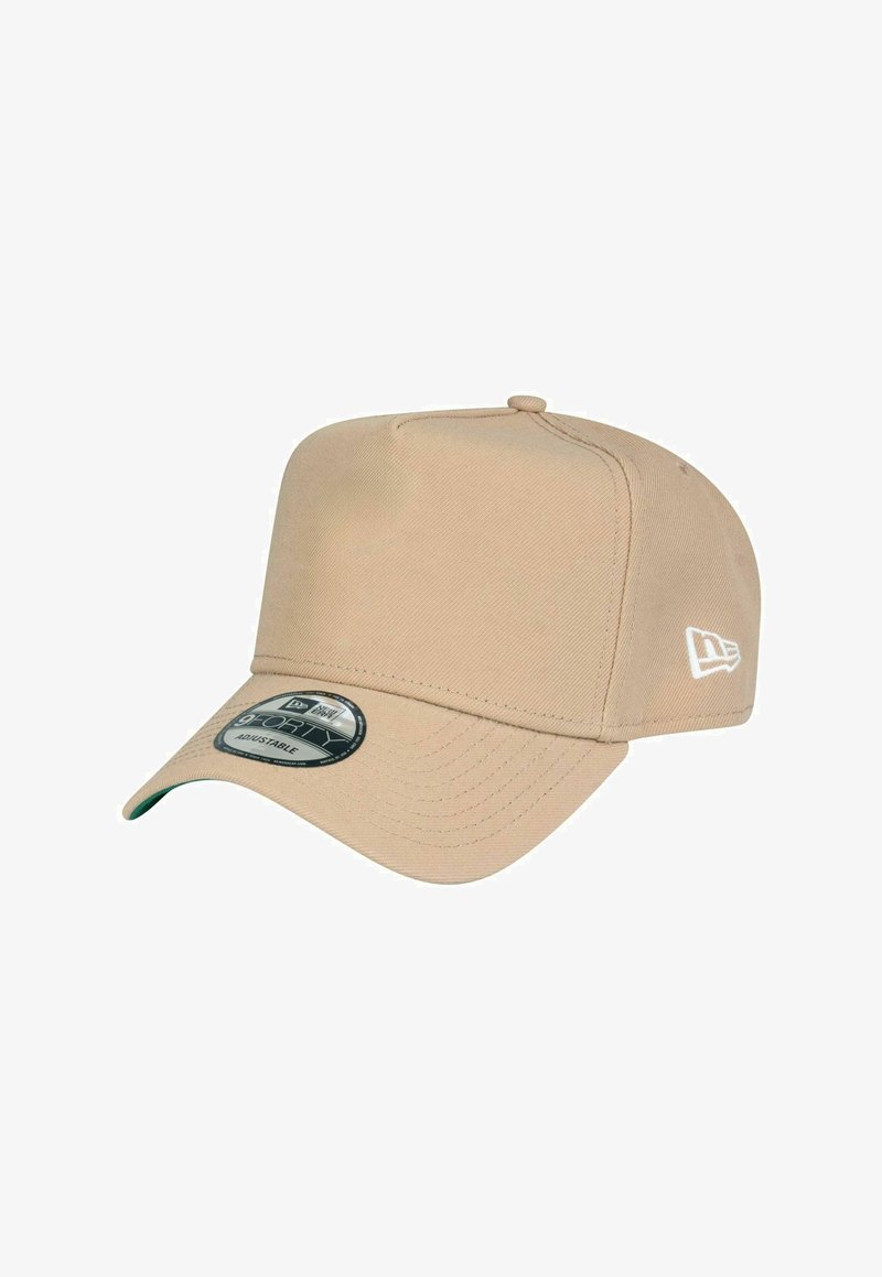 Casquette de baseball beige réglable avec une visière courbée et un logo New Era brodé en blanc sur le côté.