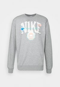 Grå sweatshirt med "NIKE" i stora vita bokstäver, prydd med färgglada grafik och ett runt märke i mitten. Tillverkad av bomull, med rund halsringning.