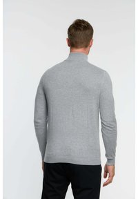 Pull gris à col roulé à manches longues, fabriqué en tissu tricot doux, présentant une silhouette ajustée et des poignets et un ourlet côtelés.