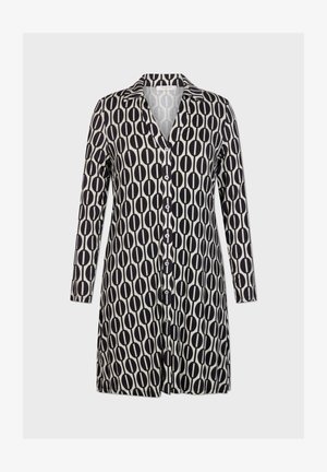 Haljina dugih rukava s crno-bijelim ovalnim uzorkom. Izrađena od mekog materijala s kopčanjem sprijeda i klasičnom ovratnikom.