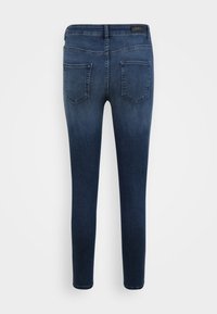 Jeans skinny em denim escuro, com uma textura suave, design de cinco bolsos e uma cintura média com um patch de logo na parte de trás.