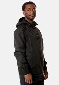 Schwarze Zip-Jacke mit Kapuze, elastischen Bündchen und seitlichen Taschen. Strukturiert der Stoff mit einem schlanken, modernen Design.