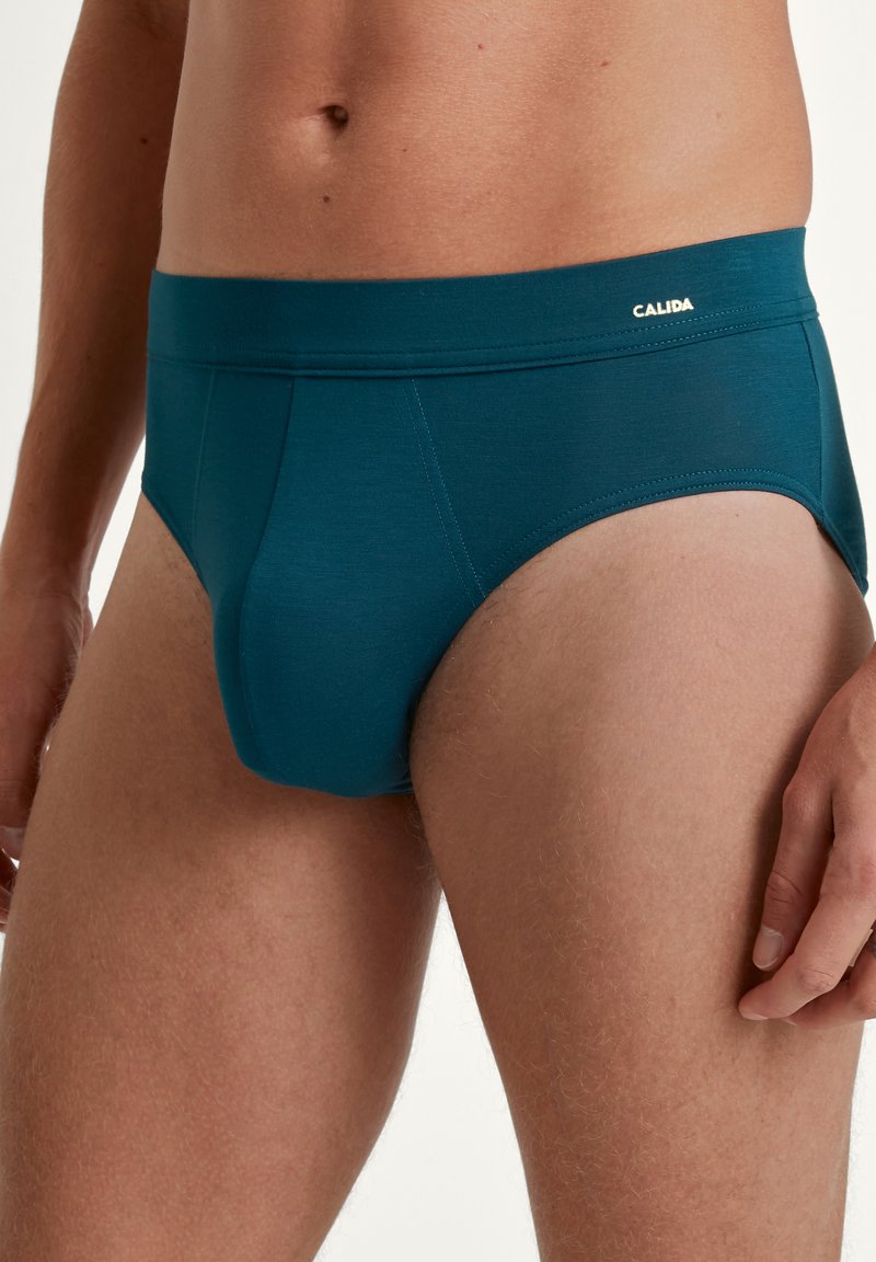 Teal herenbriefjes met een zachte elastische tailleband, voorzien van een aangesloten ontwerp en een gladde textuur. Het logo "CALIDA" is op de tailleband afgebeeld.