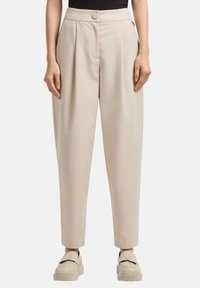 Pantaloni beige su misura con vita alta, chiusura a un bottone e pieghe. Tessuto liscio con una vestibilità rilassata e gambe affusolate.