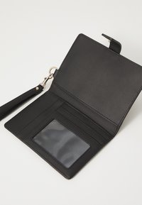 Black leather wallet with a smooth texture, featuring a clear ID slot, card slots, and a wrist strap. Opens to reveal a minimalist interior.
