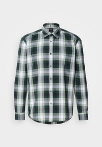 Chemise à manches longues boutonnée avec un motif à carreaux vert, blanc et gris et un col pointu sur fond blanc.