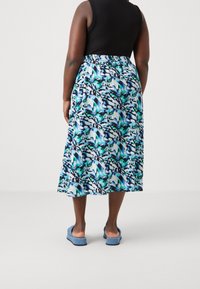 Kukkakuosiset maksihameet sinisessä, vihreässä ja valkoisessa, mustalla abstraktilla kuviolla; joustava vyötärö; yhdistetty vaaleansinisiin liukuvaan kenkään.