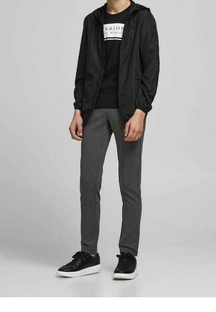 Schwarze Kapuzenjacke, schwarzes Grafik-T-Shirt, graue Slim-Fit-Sweatpants und schwarze Sneaker mit weißen Sohlen. Einfaches und funktionales Design.