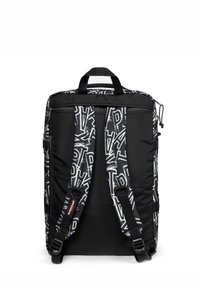 Svart ryggsäck med en strukturerad design som har vit grafisk text. Inkluderar justerbara vadderade axelremmar och ett handtag upptill.