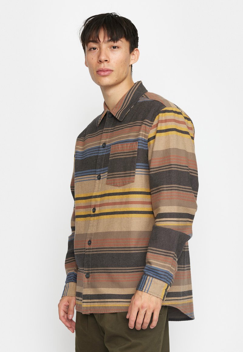 Langarmshirt met horizontale strepen in bruin, beige, blauw en geel. Gemaakt van een textuurstof en voorzien van een borstzak.