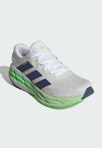 White athletic shoe with green and navy accents, textured upper, padded collar, rounded toe, and distinct three-stripe design.