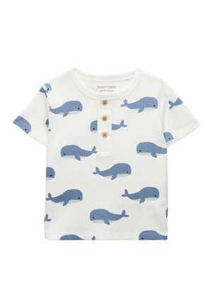 T-shirt blanc à manches courtes pour tout-petit avec motif de baleine bleue et trois boutons en bois sur la patte de boutonnage avant.