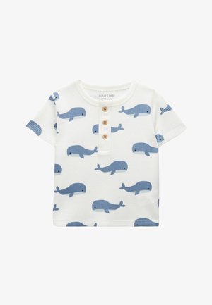 T-shirt blanc à manches courtes pour tout-petit avec motif de baleine bleue et trois boutons en bois sur la patte de boutonnage avant.