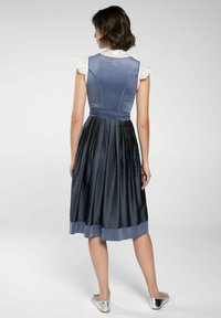 Blauwe fluwelen lijfje met geraffineerde kraag, geplooide donkerblauwe rok en zilveren ballerina's. Satijnen accenten bij de zoom en taille.