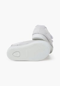 Sneaker grigie in suede con suole in gomma testurizzata, caratterizzate da un design pulito e un marchio sottile, viste dal retro e leggermente angolate.