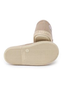 Beige slip-on espadrille with woven jute midsole and textured rubber sole, displayed with the sole facing forward.