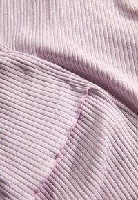 Lichtpaars geribbeld stof met een subtiele glans, voorzien van dunne, verticale strepen en een zachte textuur. De randen hebben een gladde roze afwerking.