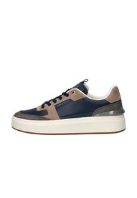 Marine leren sneakers met suède accenten in bruin en grijs, met een dikke witte zool, ronde teen en blauwe veters.