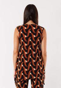 Tunica senza maniche nera con un motivo geometrico, caratterizzata da forme ondulate arancioni e beige. Tessuto morbido con una leggera lucentezza e orlo posteriore più lungo.