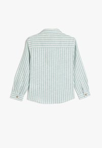 Camicetta a maniche lunghe blu chiaro con righe bianche verticali, dotata di colletto classico e polsini con bottoni. Tessuto morbido, vestibilità comoda.