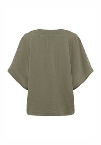 Olíva zöld blúz, könnyű anyagból készült, laza szabású, széles ujjaival és egyszerű, kerek nyakkivágásával, texturált felülettel.