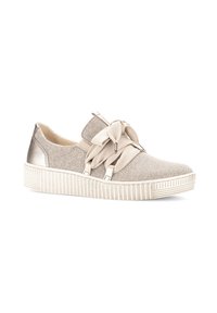 Beige canvas sneakers with a textured surface, decorative bow on the front, and a white striped sole. Metallic accents on the heel.