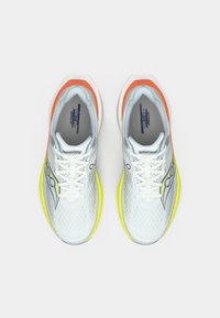 Bijele atletske cipele s mrežastim gornjim dijelom, narančastim i žutim detaljima, podstavljenim đonom i istaknutim logom sa strane.