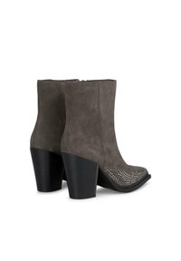 Botas de tobillo de ante gris con punta afilada, tachuelas decorativas plateadas en el frente y un tacón negro apilado. Cierre con cremallera en la parte trasera.