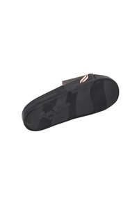 Profil av svarta sko i slip-on modell med en texturerad gummisula och rund form. En rosa accentrand syns på den övre delen.