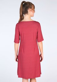 Rotes Kleid mit Wellenmuster, kurzen Ärmeln, einem Bootsausschnitt und lockerer Passform. Glattes Material mit mittellanger Schnittführung.