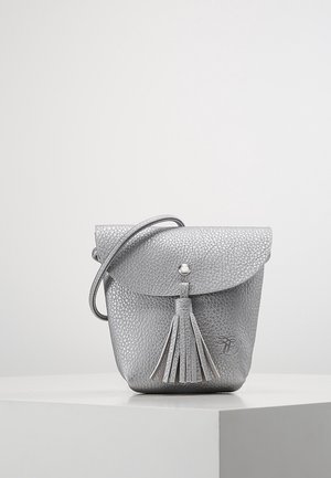 Lille sølv textured læder crossbody taske med flaplukning, frynsedetalje og tynd skulderrem på hvid overflade.
