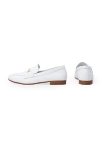 Witte leren loafers met een gouden accent aan de voorkant, lage bruine hak, gladde textuur en een ronde vorm. Inclusief zij- en achteraanzicht.
