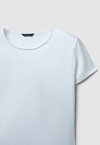 Blusa bianca a maniche corte con scollatura rotonda, realizzata in tessuto liscio. Presenta un design semplice e pulito, senza decorazioni.