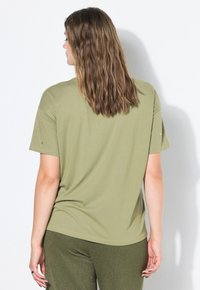 Oliwkowo zielony, krótki rękaw T-shirt wykonany z miękkiego materiału; luźny krój z zaokrąglonym dekoltem i subtelnymi detalami przeszyć.