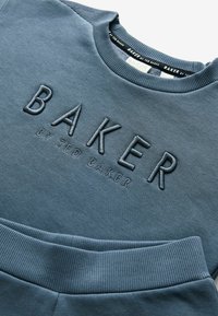Bluza z okrągłym dekoltem w stonowanym niebieskim kolorze, z wyszywanym logo "BAKER" oraz ściągaczami u rękawów i u dołu. Miękka tekstura i swobodny krój.